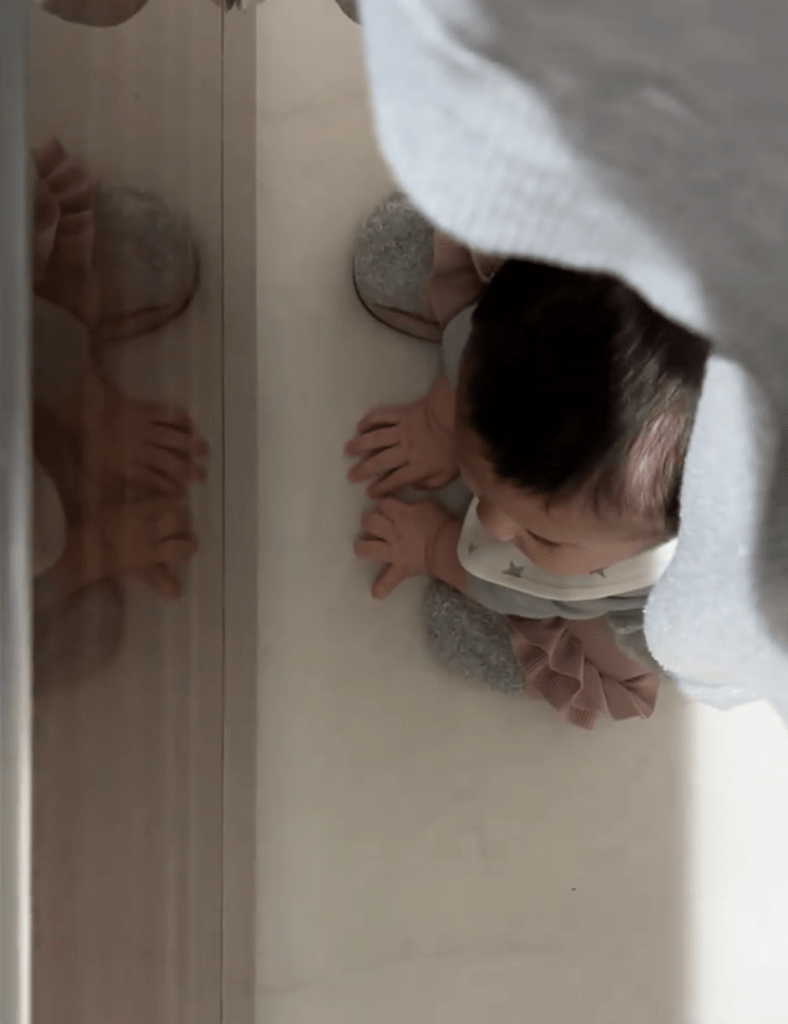 ママさんの足の間から小さな手が（@sakubaby_413さんより提供）