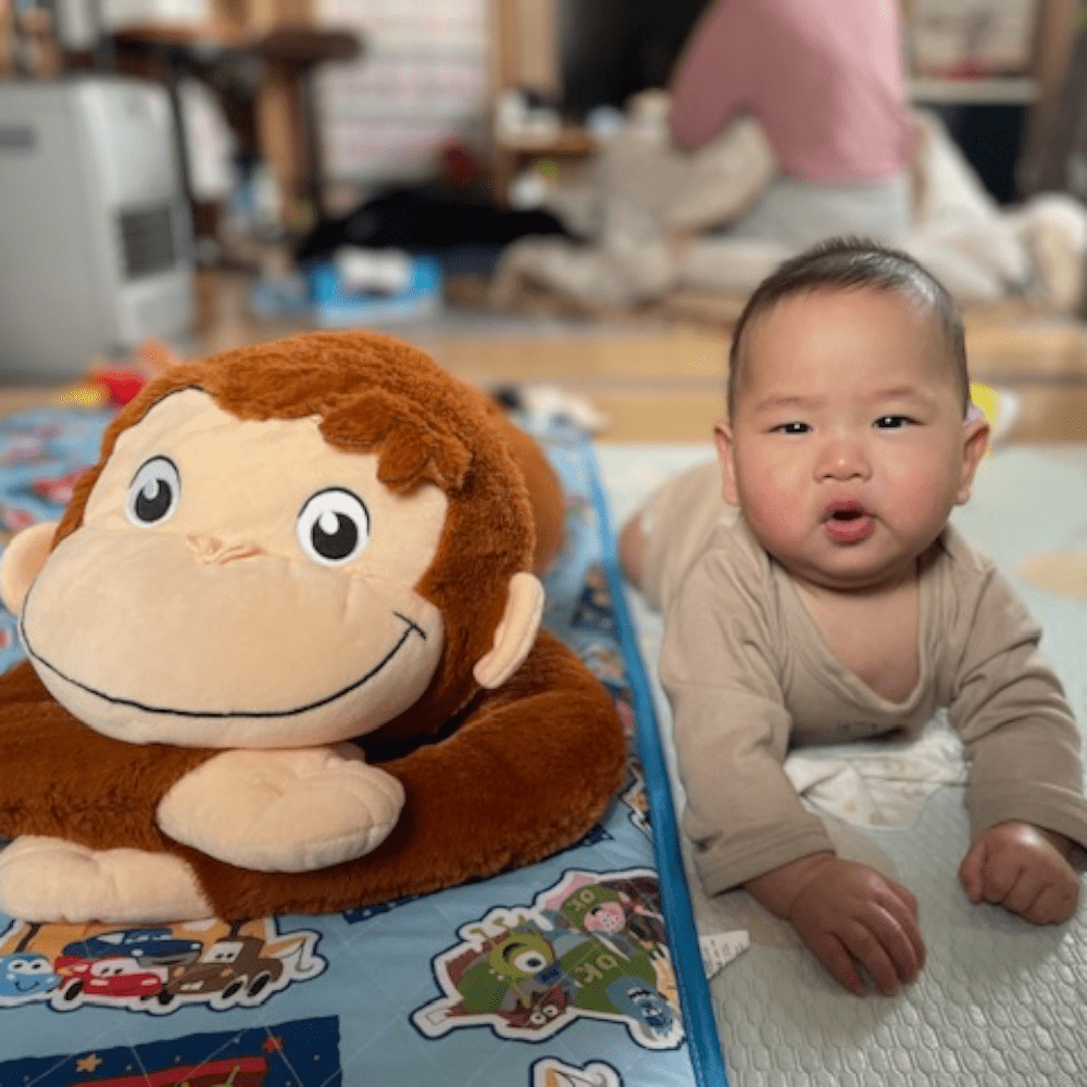 お猿のぬいぐるみと並んでこちらを見る息子さん（@stlovmxe587さんより提供）