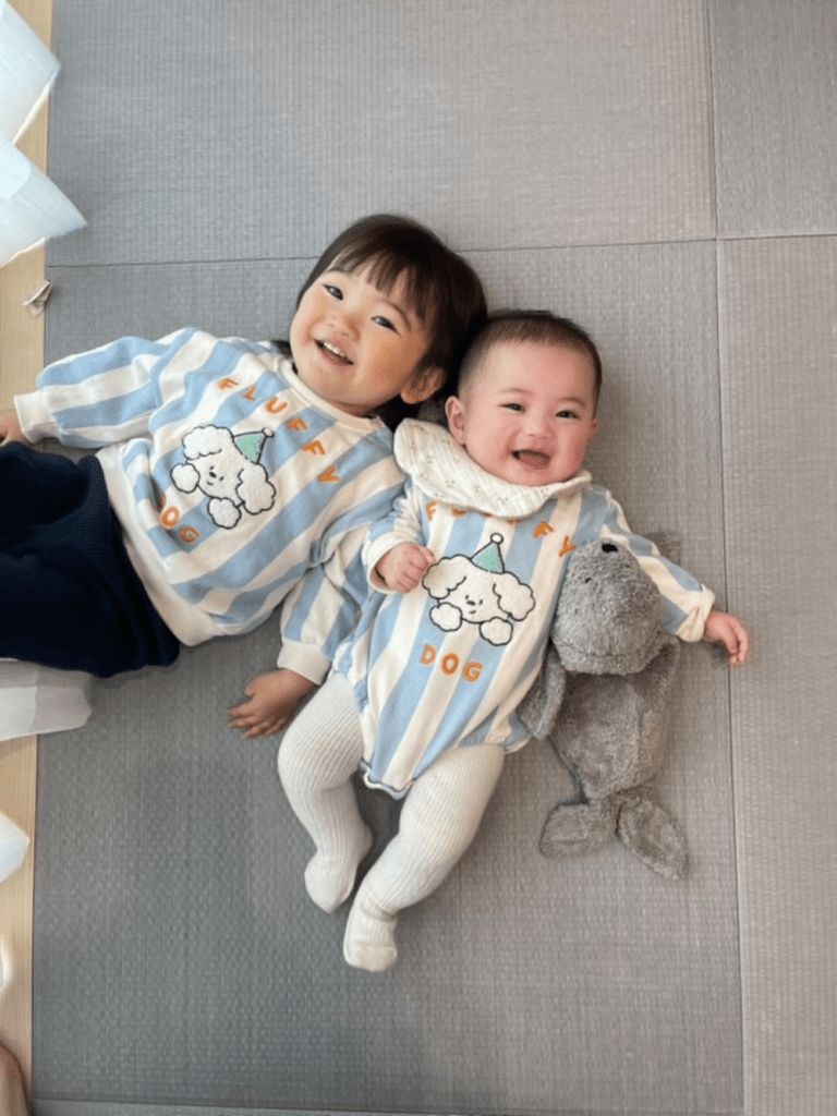 お揃いの服で仰向けに並んで笑う2人（@__sr.naさんより提供）