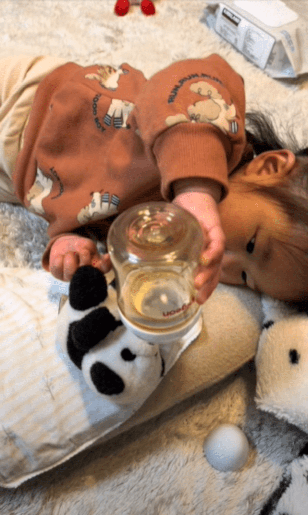 一緒に横になってぬいぐるみにミルクをあげる娘さん（@u_chan.k0815さんより提供）