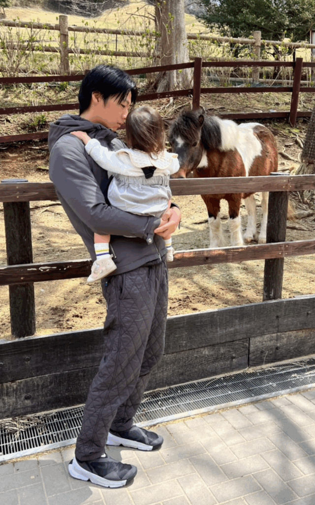 パパさんに抱っこされてポニーを見つめる娘さん（@_jurixmitsu_さんより提供）
