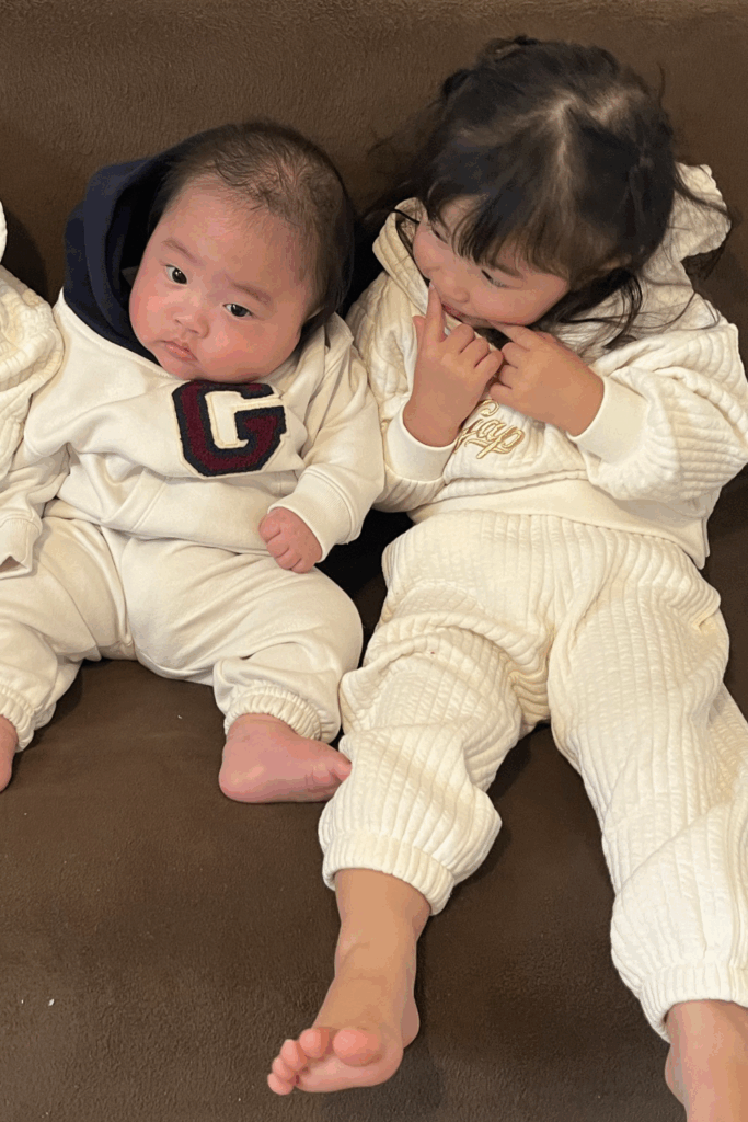 2歳上のお姉ちゃんと並んでソファに座る息子さん（@gdyyddtuさんより提供）