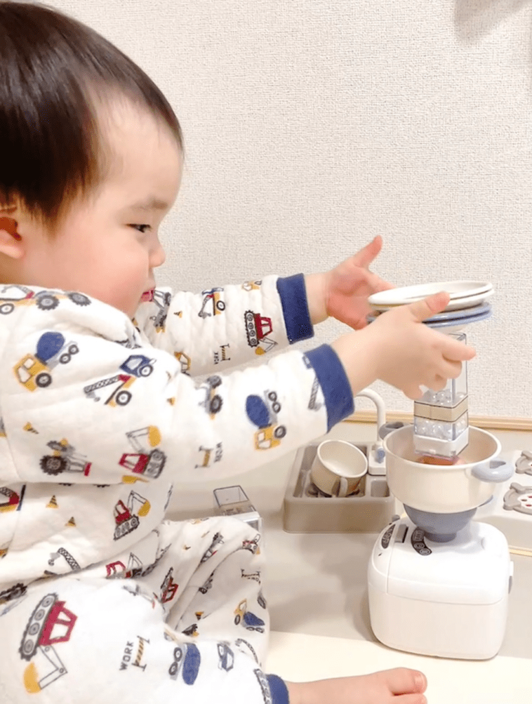 おもちゃのカップや皿を積み上げて遊ぶ息子さん（@yururi_iroさんより提供）