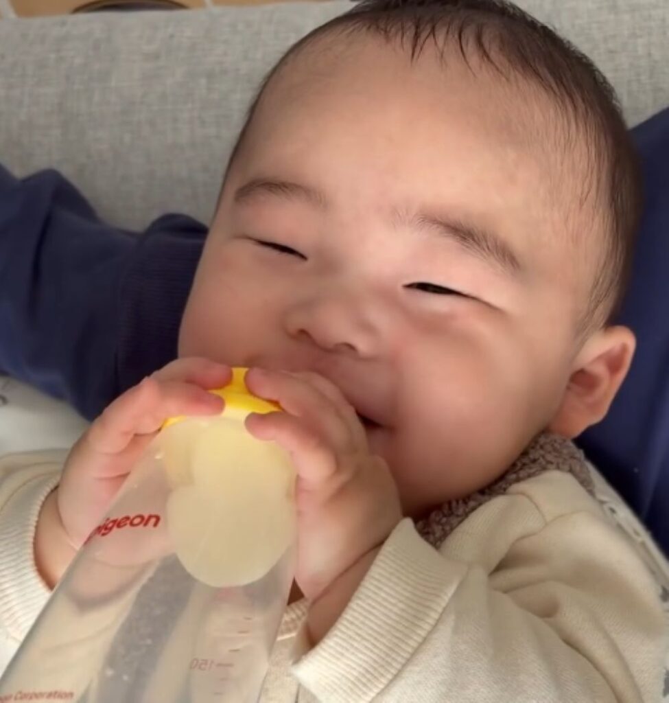 嬉しそうに哺乳瓶を持っています（＠ru.mi21さんより提供）