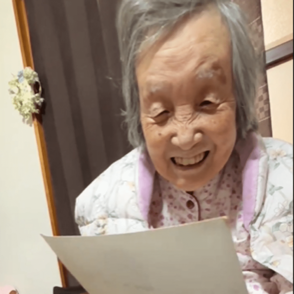 写真を見て微笑むおばあちゃん（@nonbiriobaachanさんより提供）