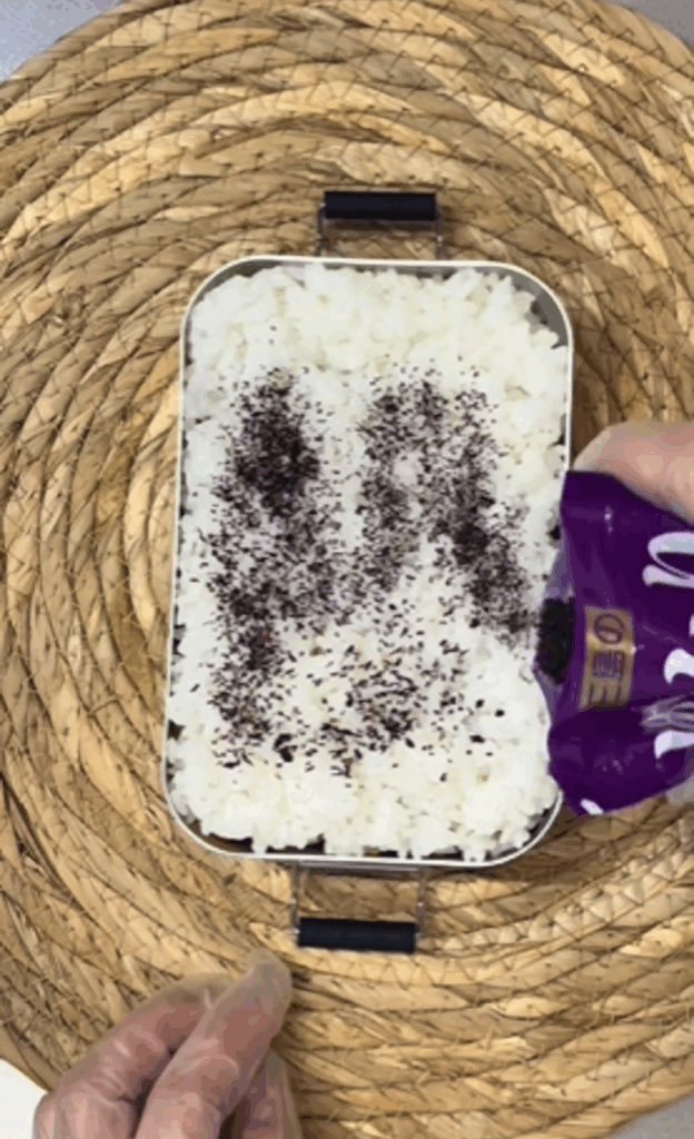 弁当上段：ふりかけをかけるところ（@__tsumaさんより提供）