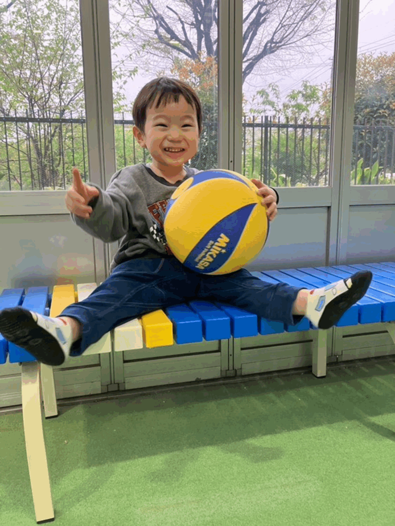 ボールを持ってベンチに腰掛ける息子さん（@takoromansaさんより提供）