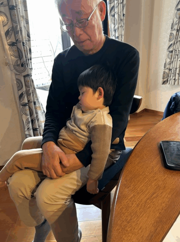 おじいちゃんの腕の中で熟睡（@hinachan0525さんより提供）