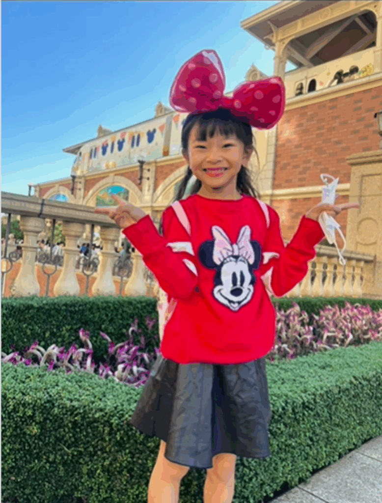 テーマパークの外で微笑むお姉ちゃん（@mayamaya0111さんより提供）