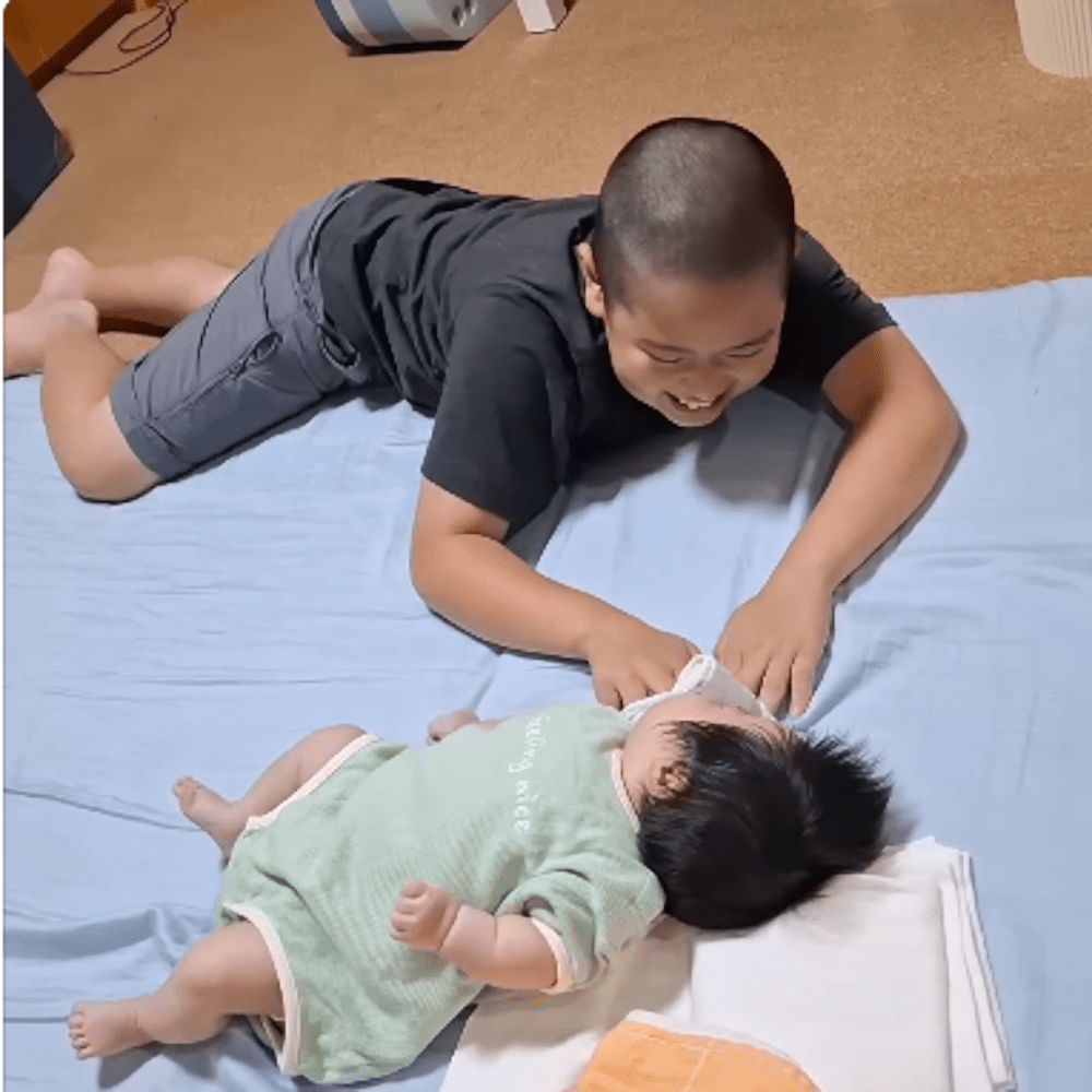 吐き戻したミルクを拭いてあげるお兄ちゃん（@kitake.4kidsさんより提供）