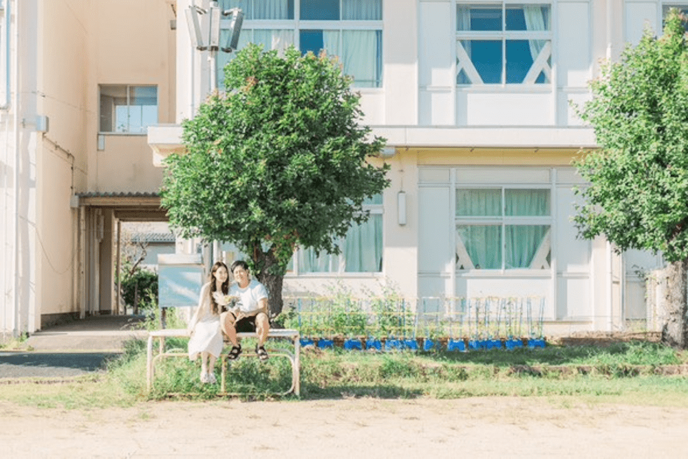 懐かしの朝礼台に座る2人（@chicchimama2021さんより提供）