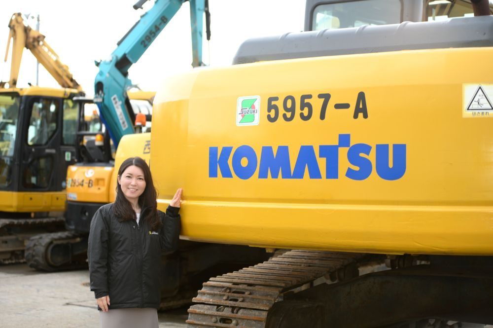 建機と一緒に写る鈴木さん（鈴木さんより提供）