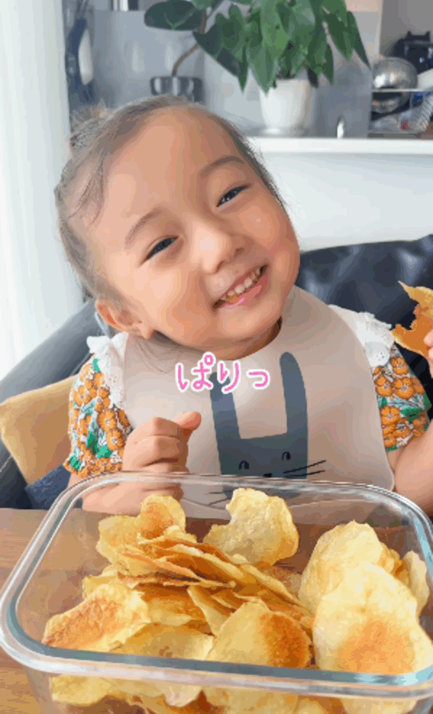 自家製のポテトチップスをおいしそうに食べる娘さん（＠saki_takada_さんより提供）