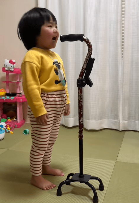 杖の前で歌う娘さん①（＠emma.k75さんより提供）