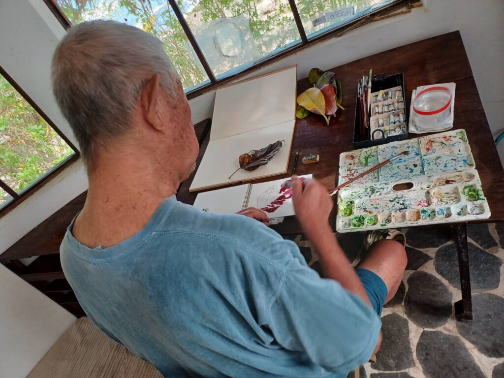 絵を描く崎山さん（提供写真）