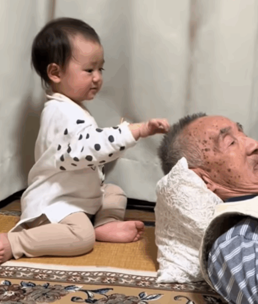 おじいちゃんの頭をつつく娘さん（＠miimegu2211さんより提供）