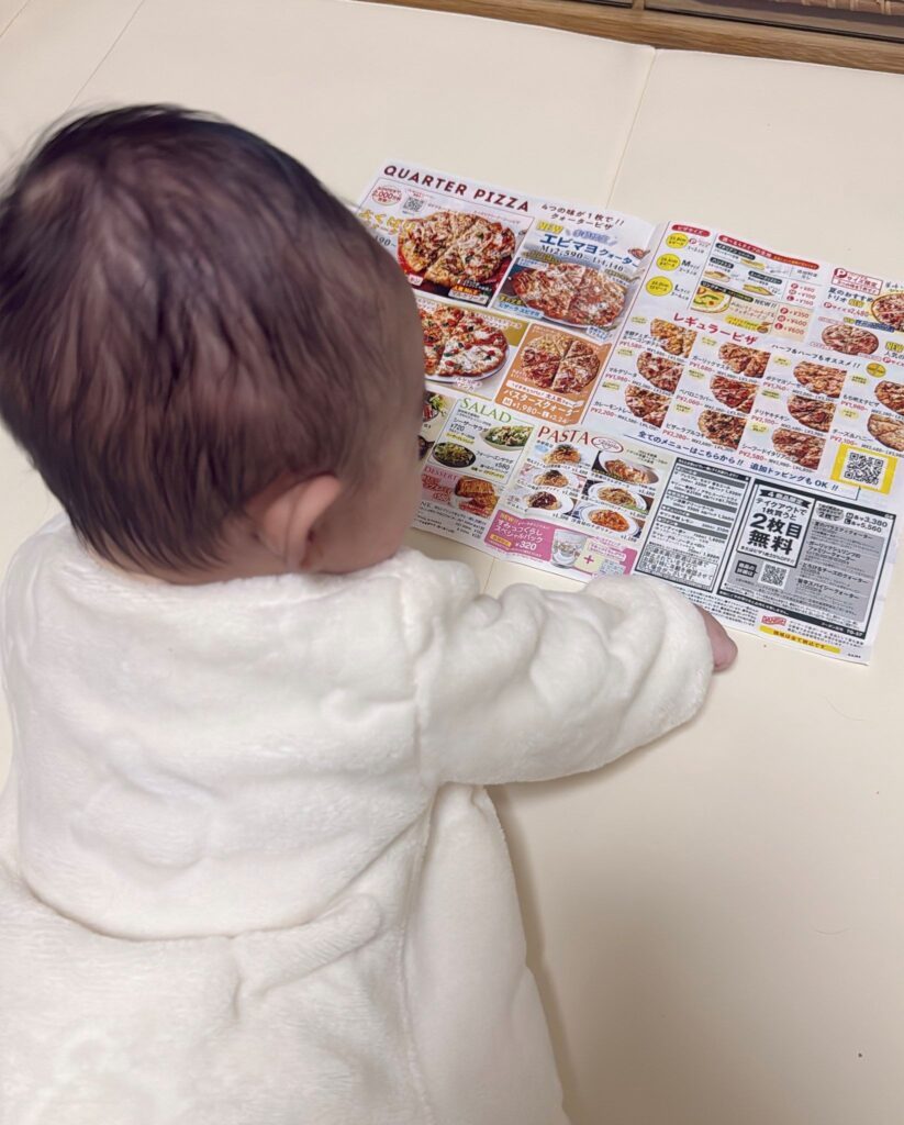 ピザのチラシを見つめる息子さん（＠yuyubaby1121さんより提供）