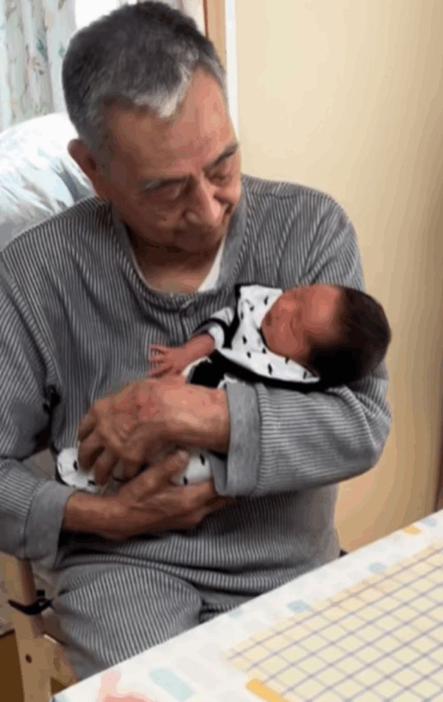 慣れた手つきで抱っこするひいおじいちゃん（@kiramama0421さんより提供）