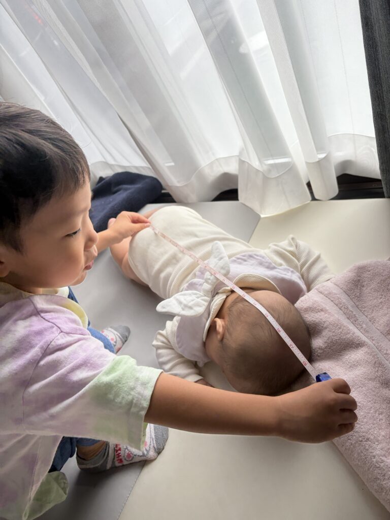 妹を測る息子さん（＠futago_no_kirokuさんより提供）