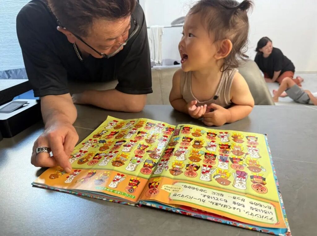 おじいちゃんと絵本を楽しむ様子（＠arm1087691さんより提供）