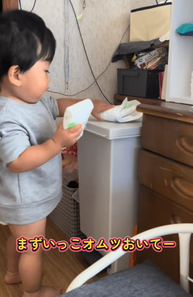 1つ目のオムツをゴミ箱の上に置く息子さん（＠usernrdngdxfjuさんより提供）