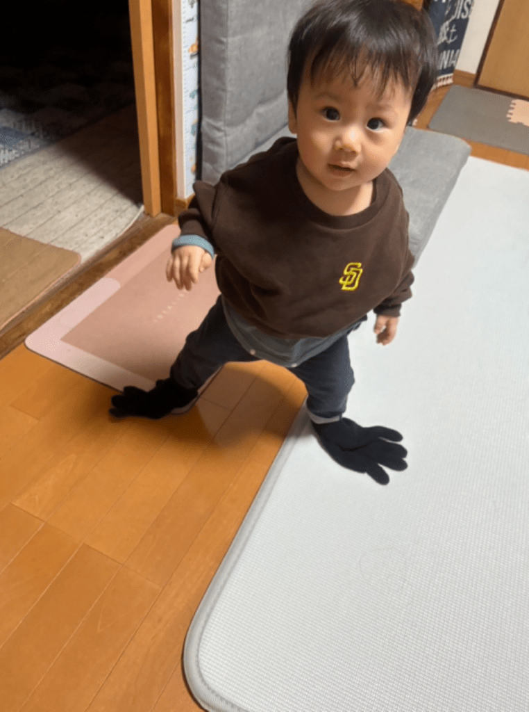 足に黒い軍手をはめてカラスの真似をしている様子（＠MRdsnqさんより提供）