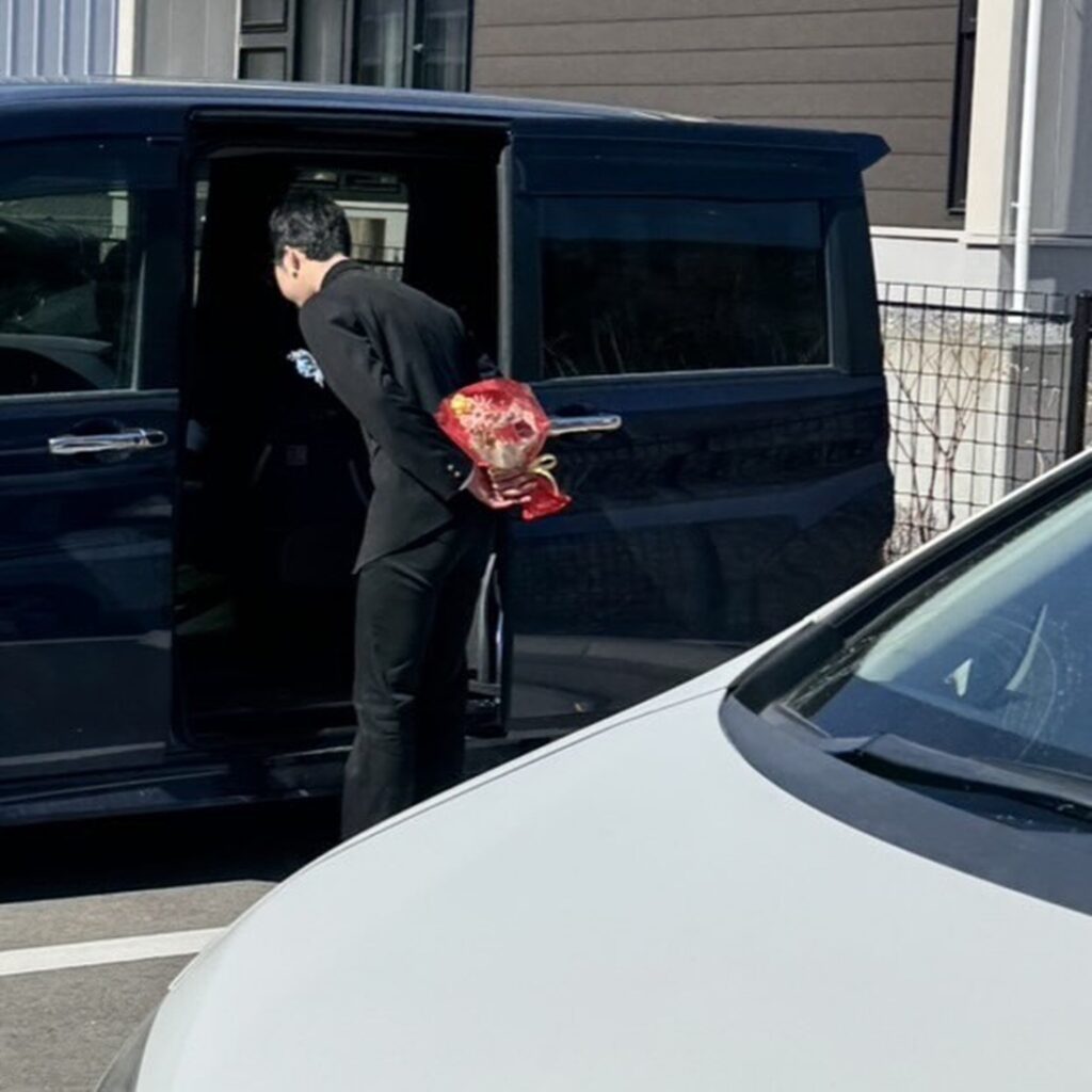花束を隠しながら車に近づく次男さん（@vul829_1984さんより提供）