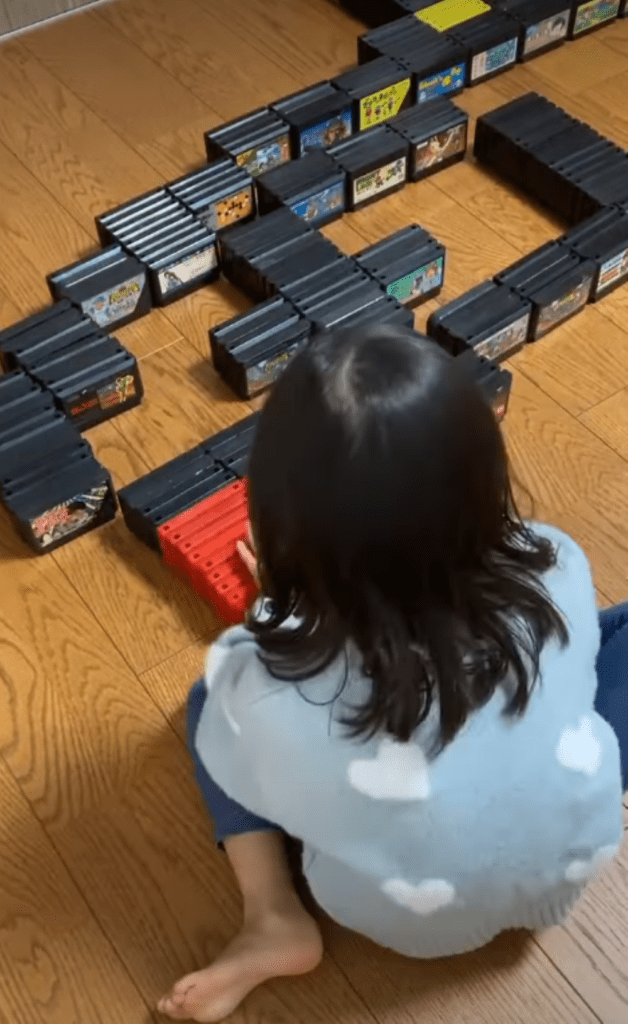 カセットを並べる娘さん①（＠famicom_artさんより提供）