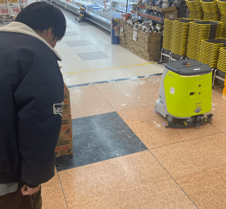 スーパーの巡回ロボットにお辞儀する友人（＠makkoi_officialさんより提供）