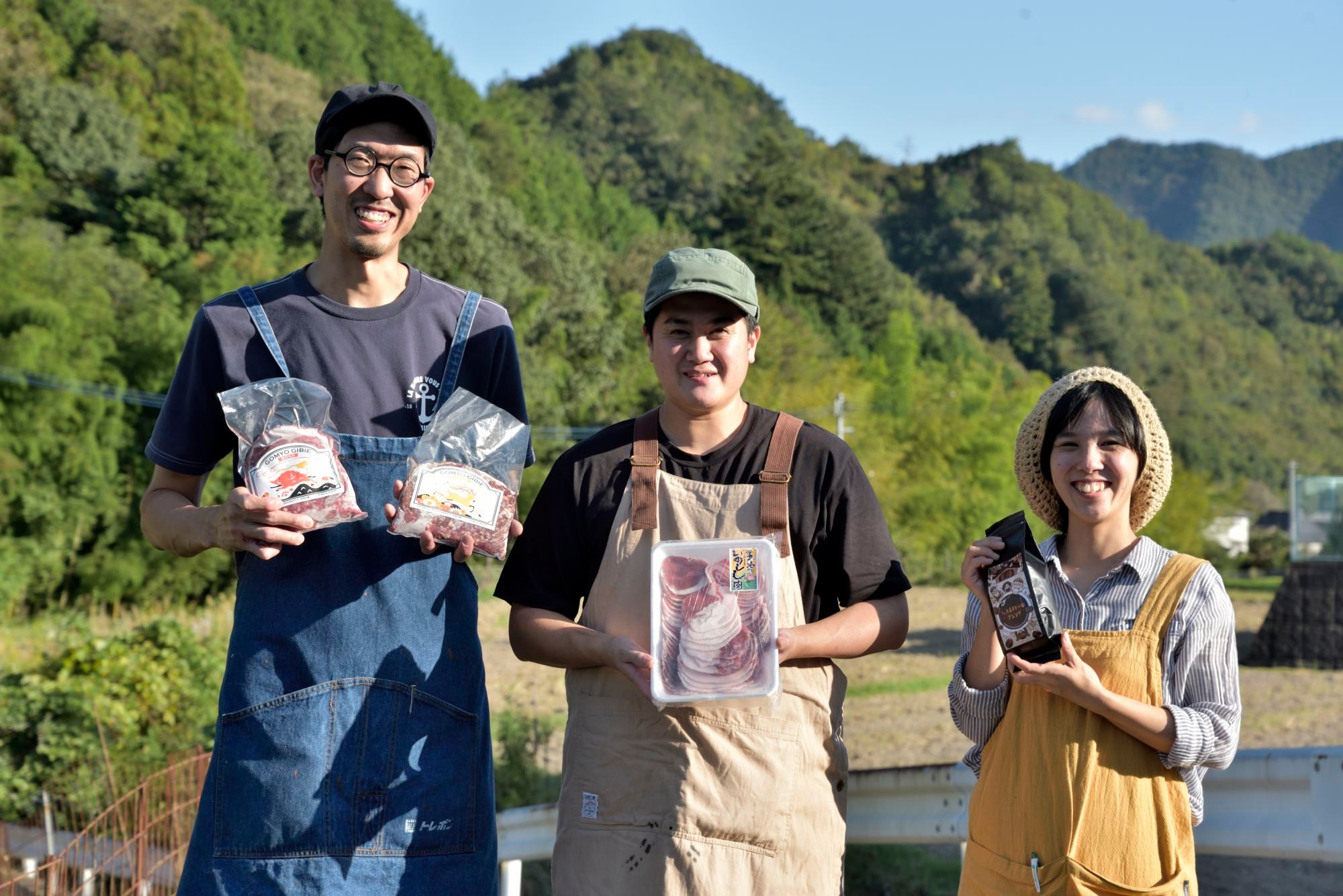 五名の里山をバックに左から飯村店長、スタッフの上田さん、スタッフで妻の遊宇さん。飯村夫妻は3歳と1歳の娘の4人家族。